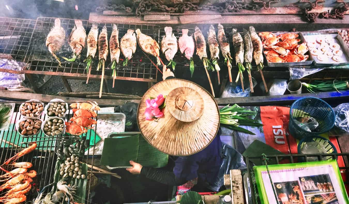 A local women selling cheap food from her small boat in Thailand