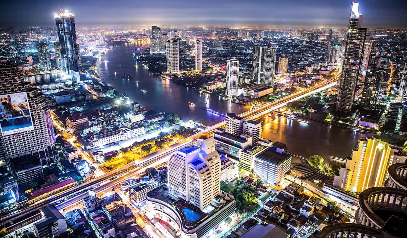 The bright, towering skyline of Bangkok, Thailand lit up at night