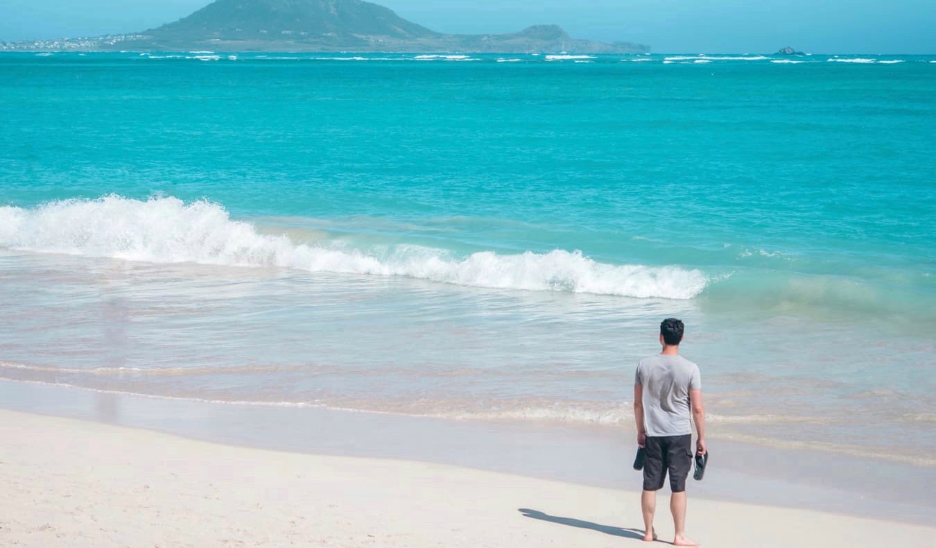 A photo of Nomadic Matt alone on a beach