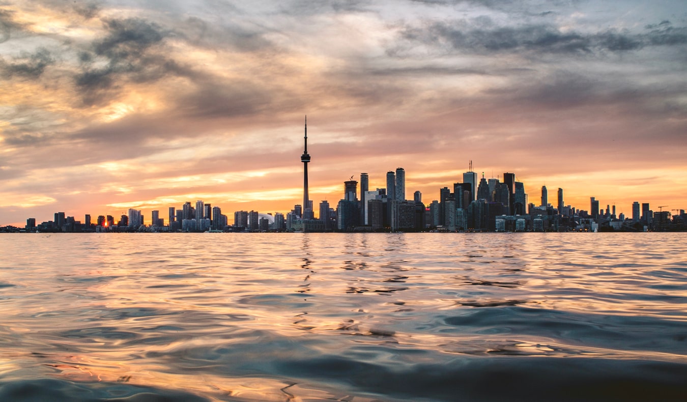 An orange sunset over the Toronto skyline in summer