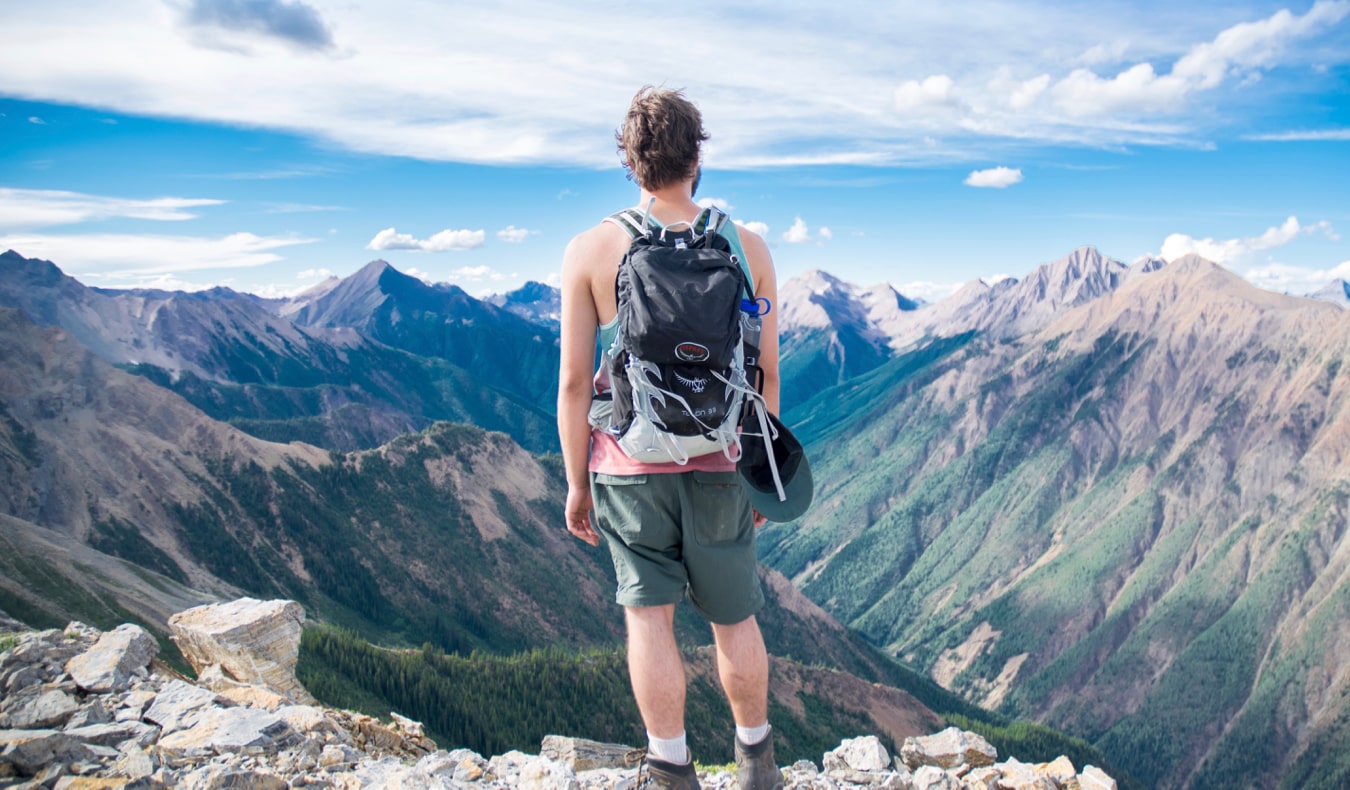 A solo backpacker standing on a cliff looking at the scenery