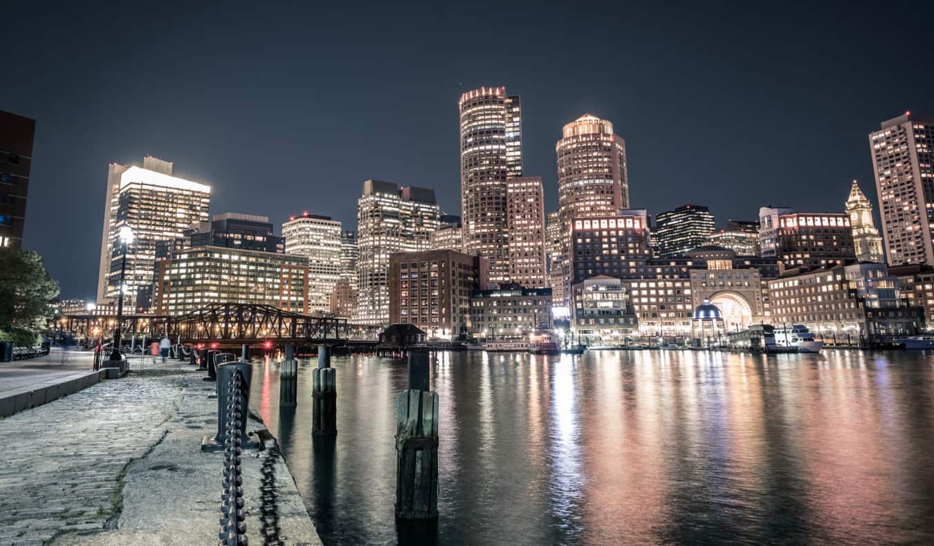 The skyline of Boston lit up at night by the water