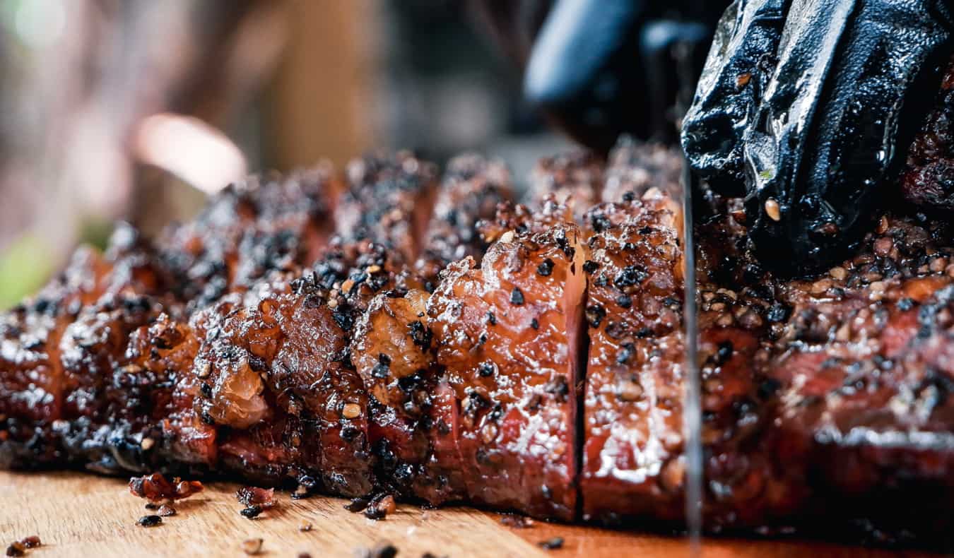 A chef cutting BBQ brisket in a restaurant