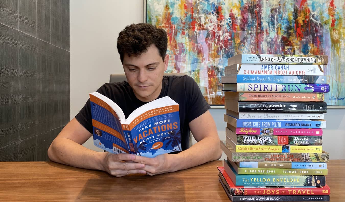 Nomadic Matt reading a travel book at a desk