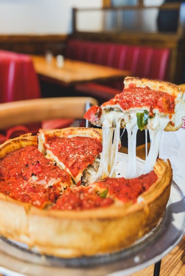 Deep dish pizza with a slice being cut out