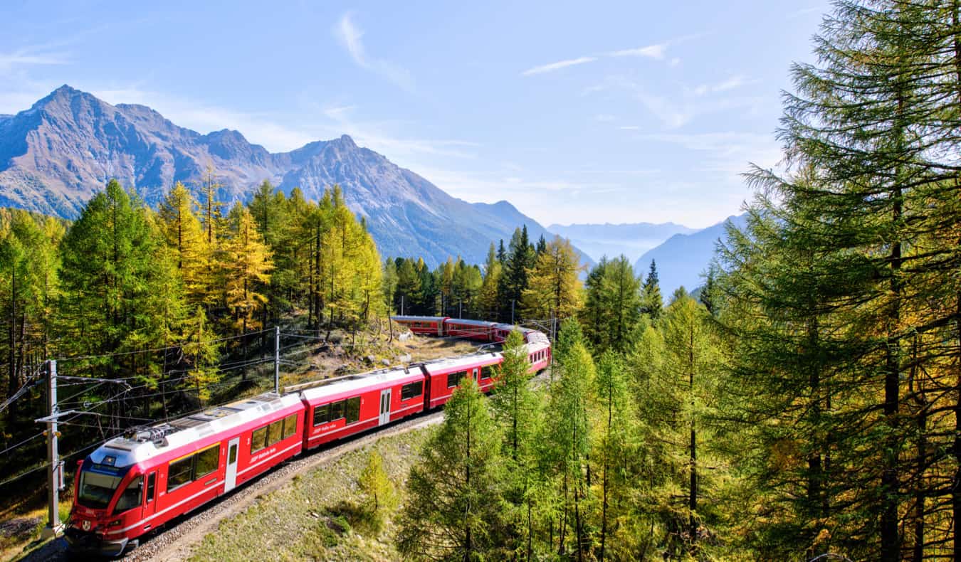 A high-speed train traveling through the snowy mountains of Europe