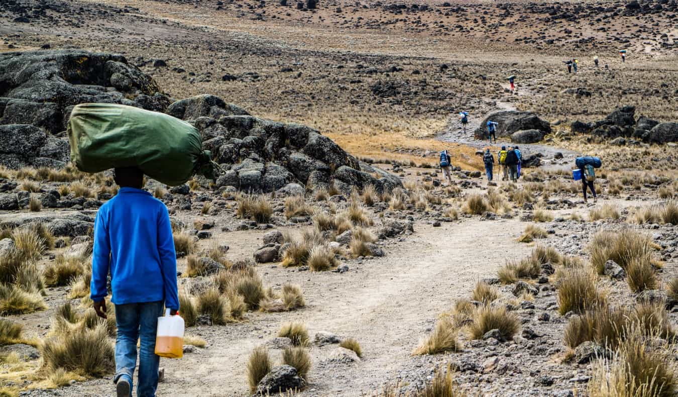 A Kilimanjaro porter carrying a large sack on his head