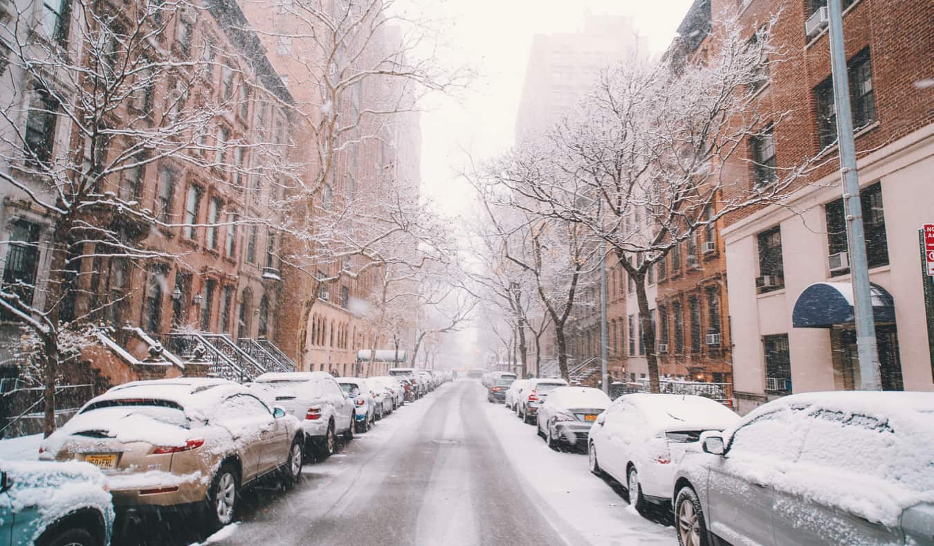 street view of the Upper West Side NYC with a yellow taxi waiting at a red light