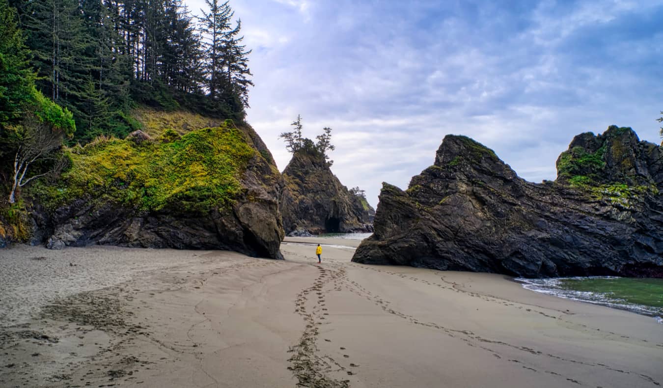 A solo traveler walking on the beach in Oregon, USA