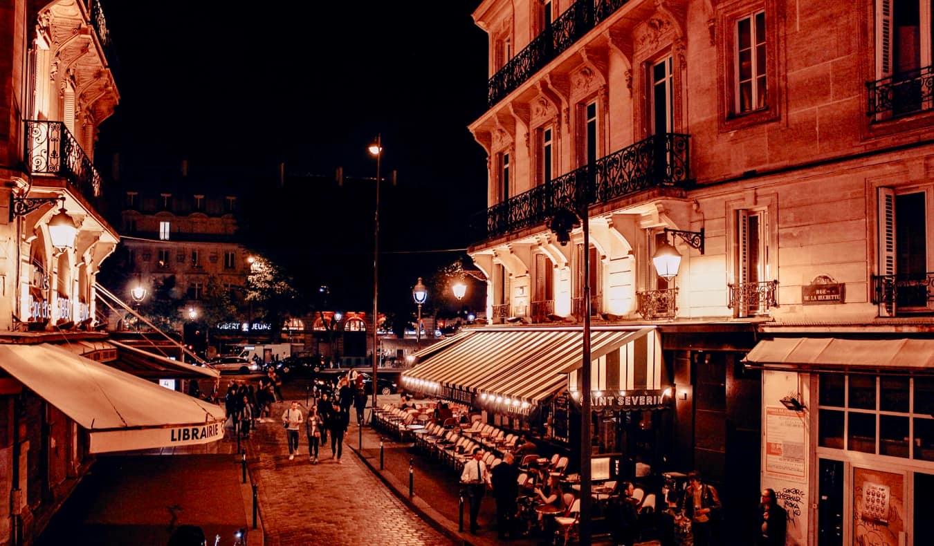 The patio of a busy bar a night in Paris, France