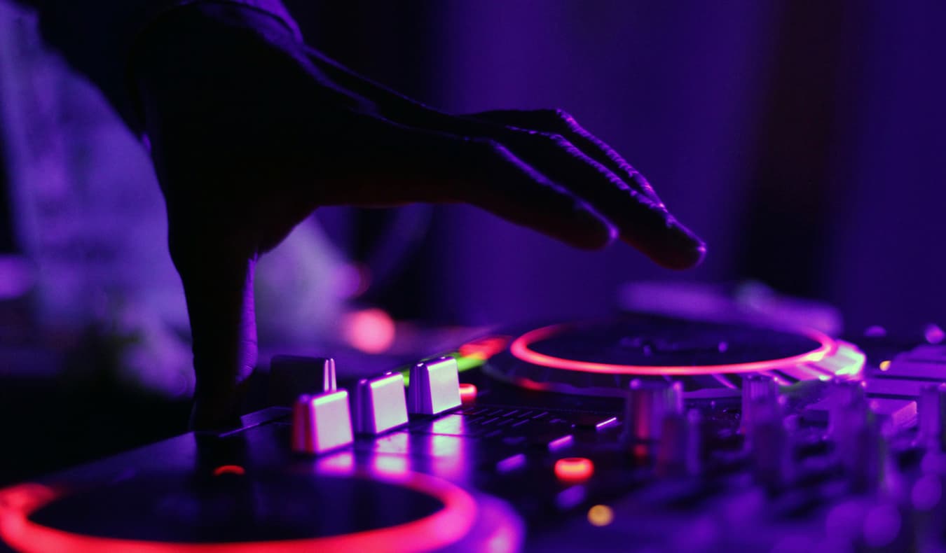 A turntable at a rave with neon lights