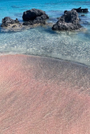 The pink sand beach and clear waters of Crete, Greece