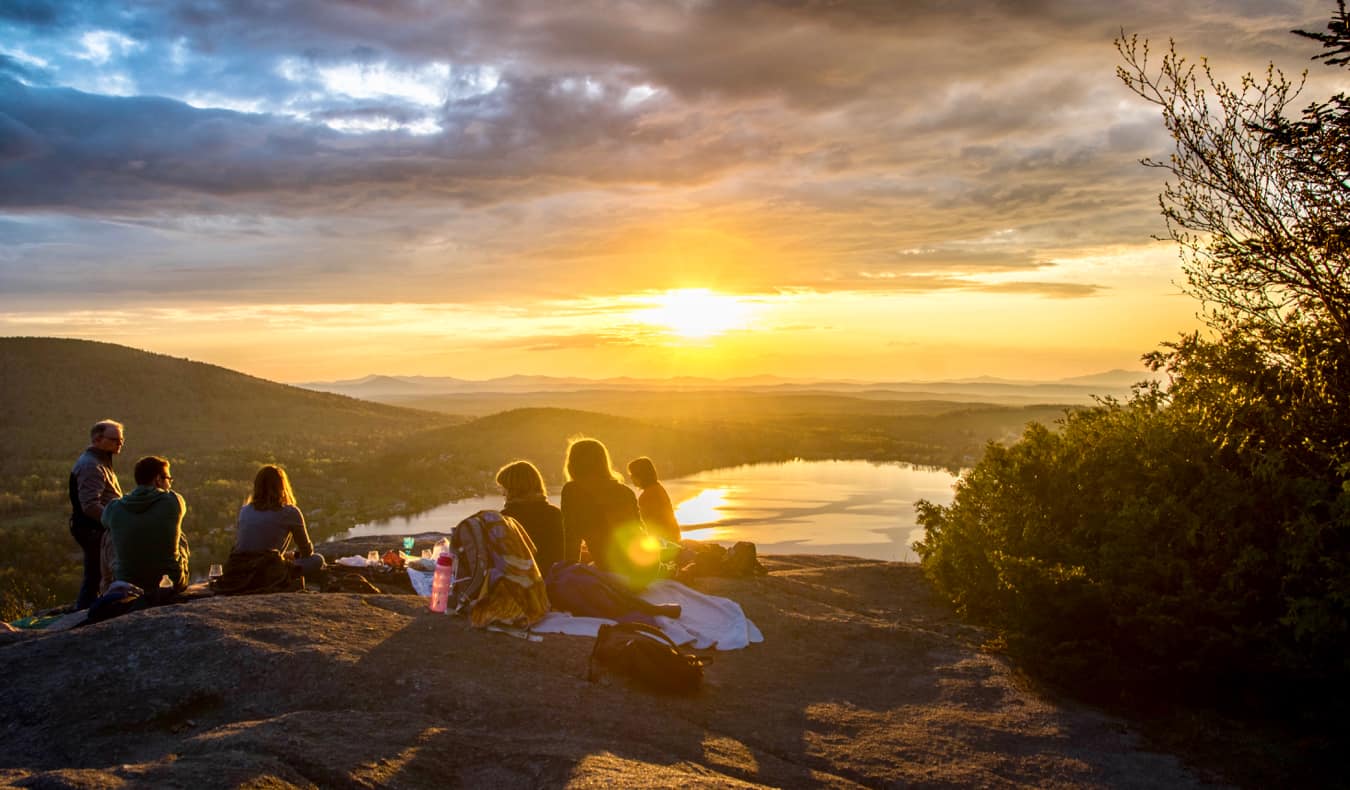 A group of friends having a picnic at sunset