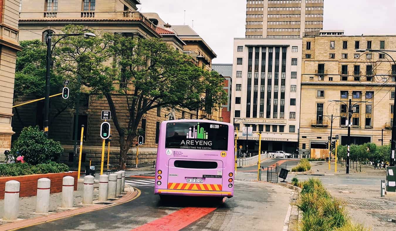 A coach bus driving in a city in South Africa