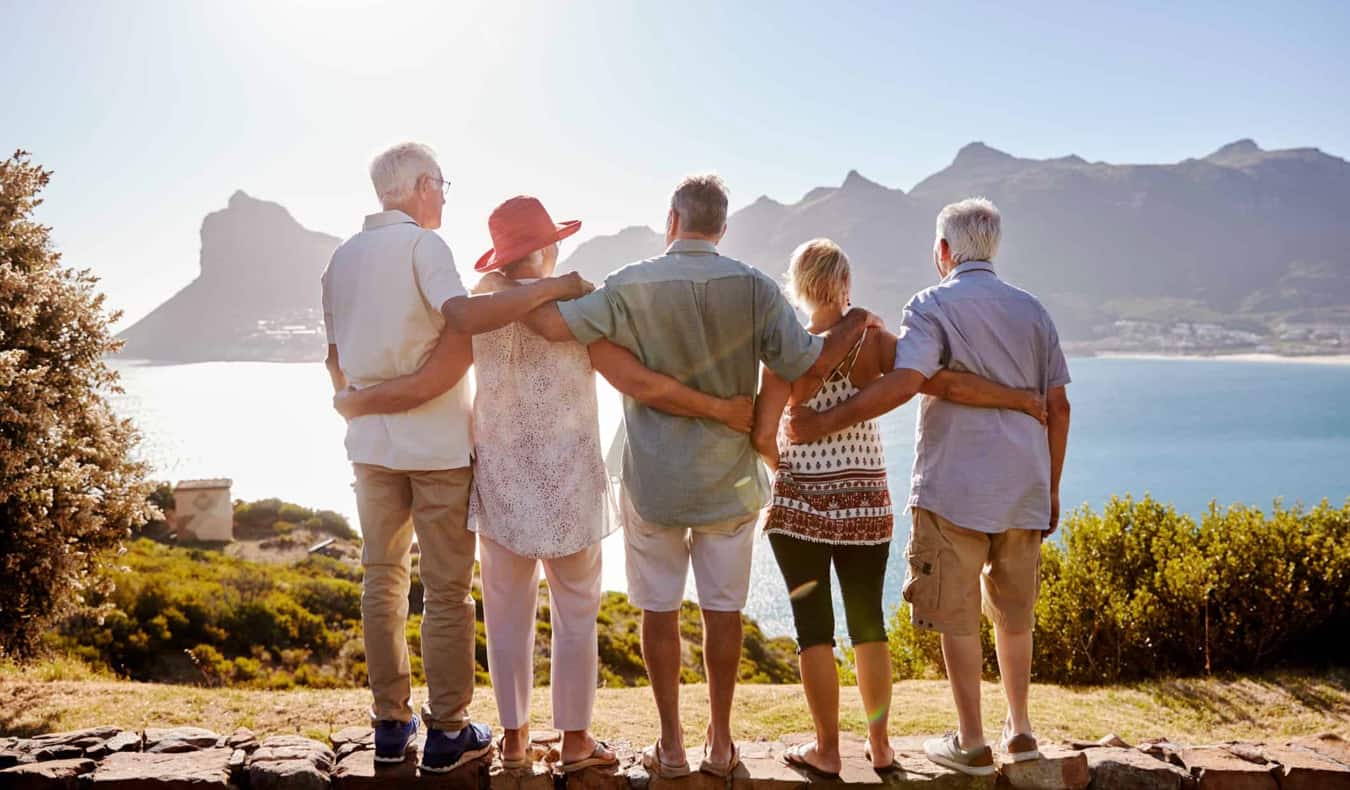 A group of senior travels posing in a warm destination