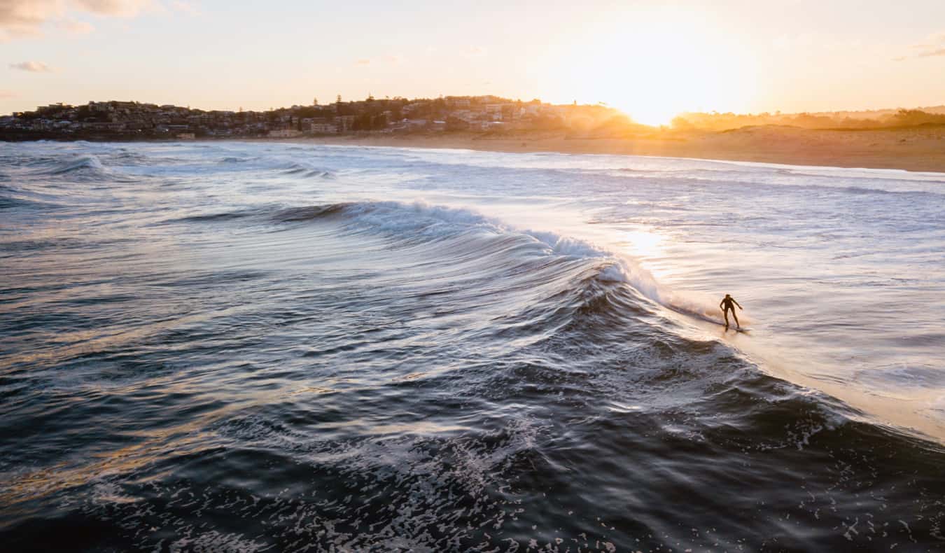 A surfer in the water surfing in Sydney, Australia