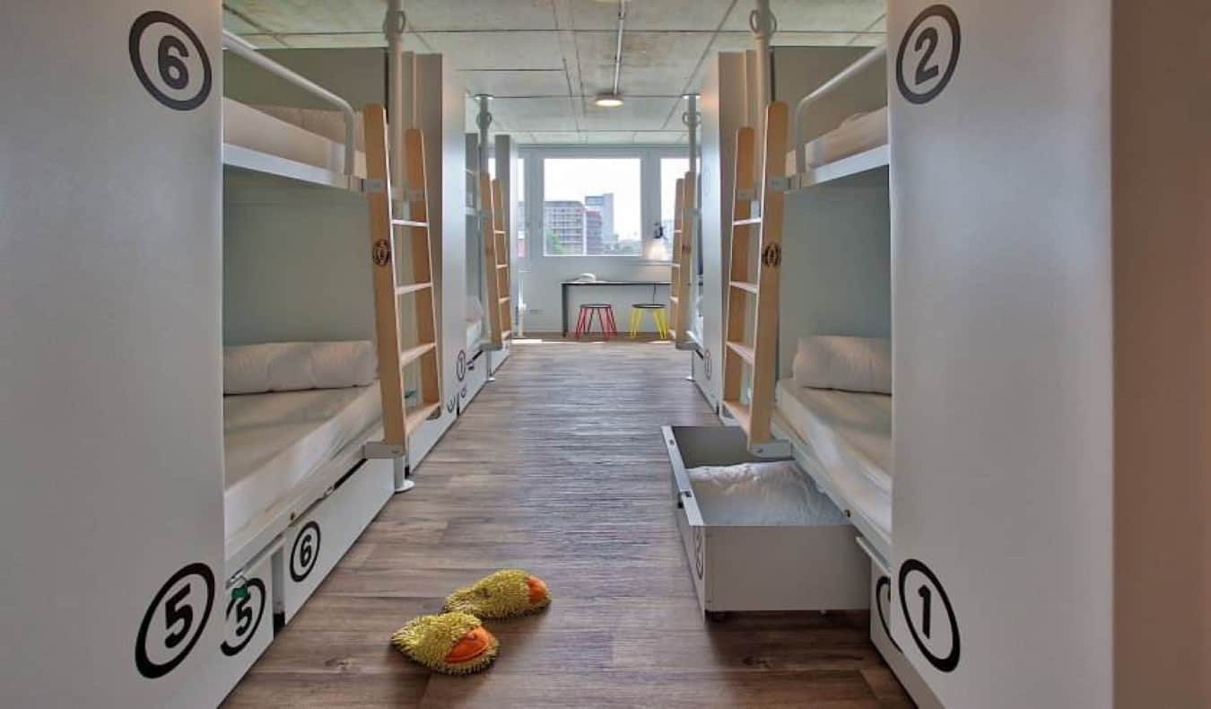 White bunk beds in a bright room at Anda Hostel in Venice, Italy.