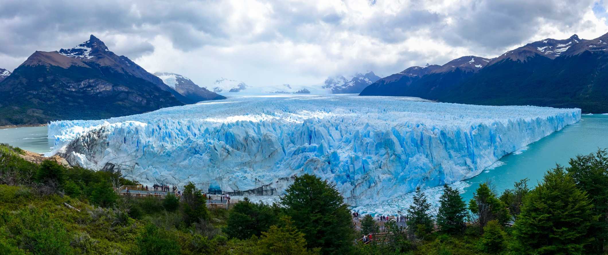 The stunning, towering mountains of Patagonia, Argentina under a pristine blue sky, with a large glacier in the foreground