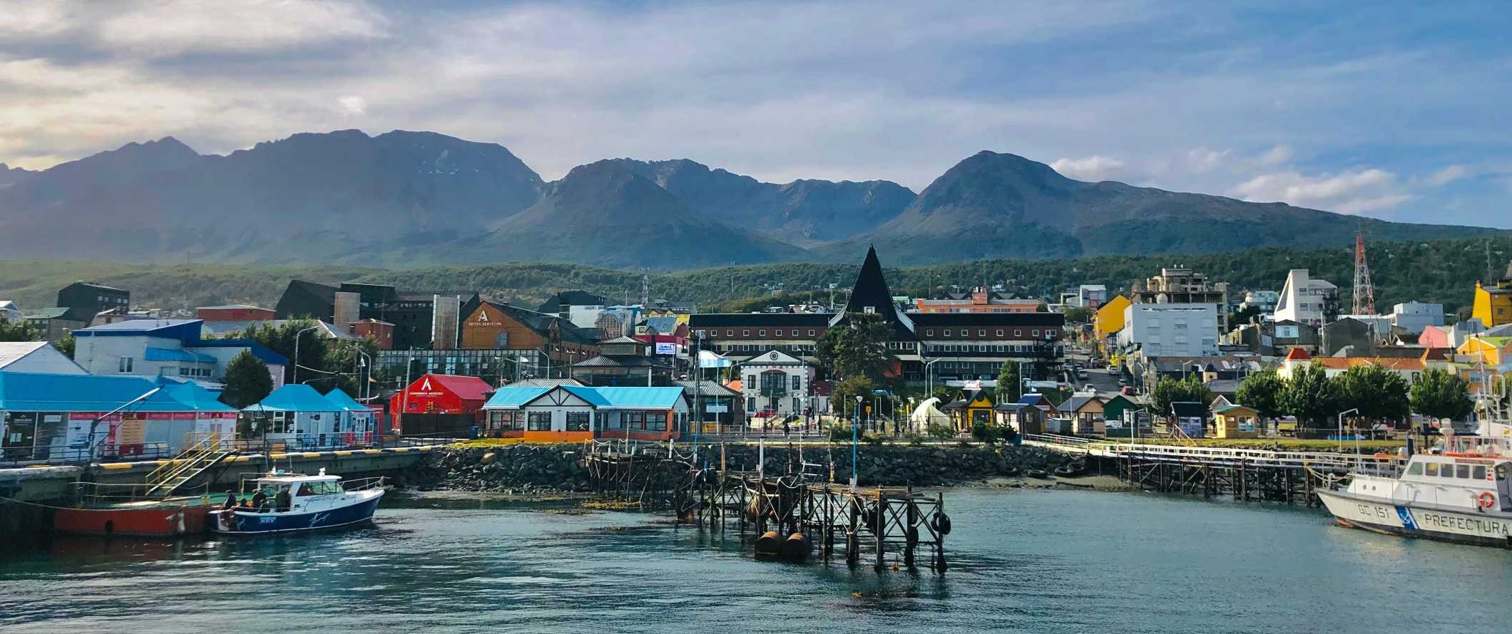 Colorful houses along a waterfront lined with docks in the village of Ushuaia, the southernmost city in Argentina