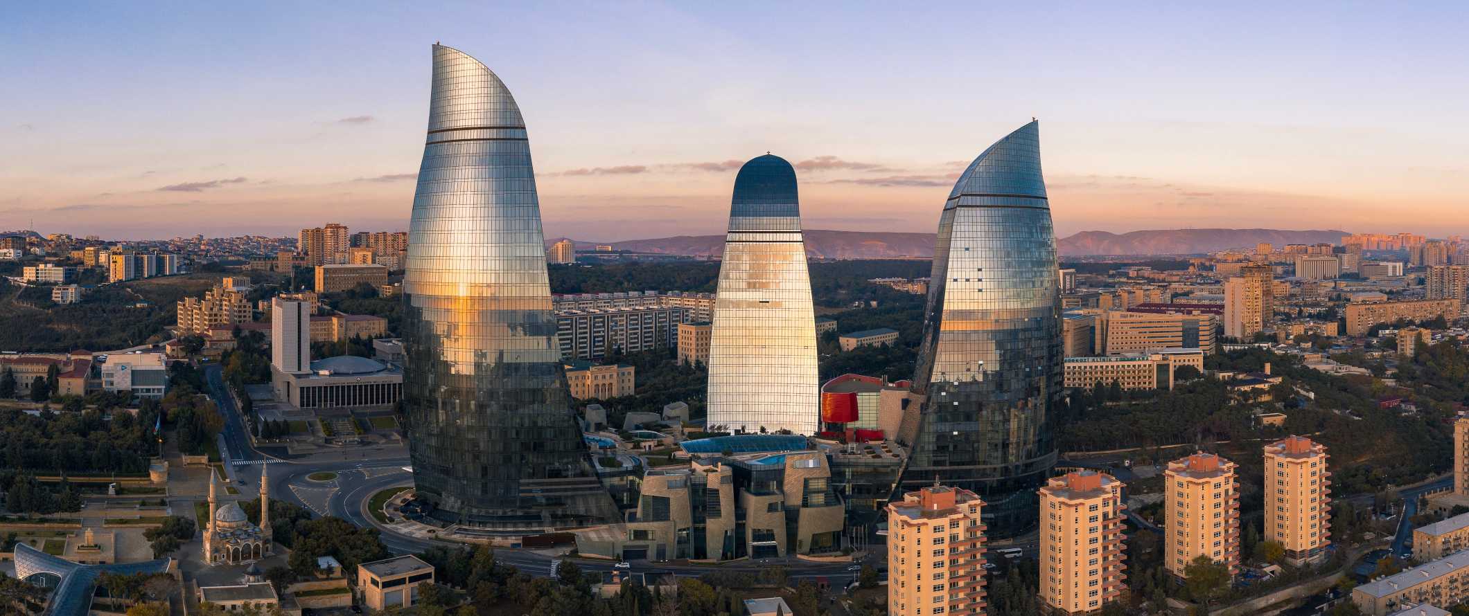 The towering Flame Towers in Baku, Azerbaijan overlooking the city at sunset