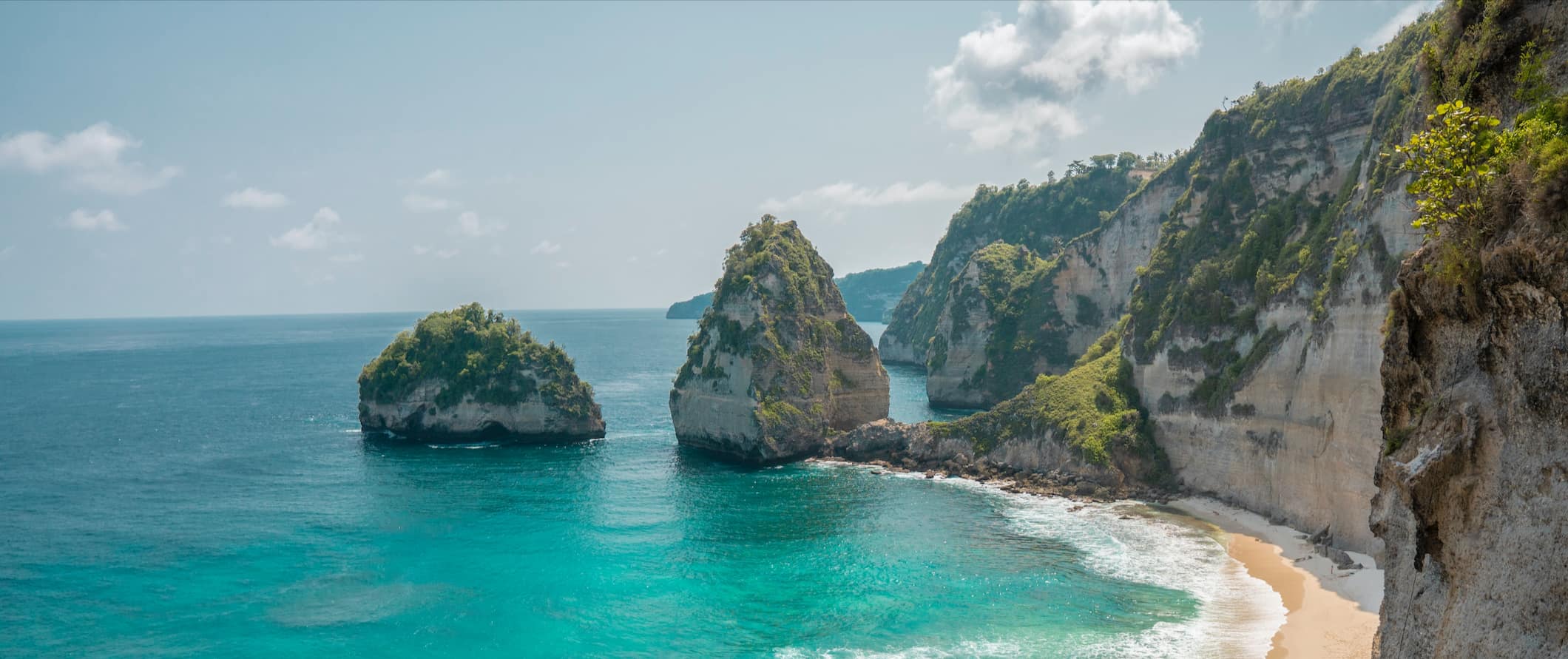 A stunning beach alongside the rugged cliffs and coast of Bali, Indonesia
