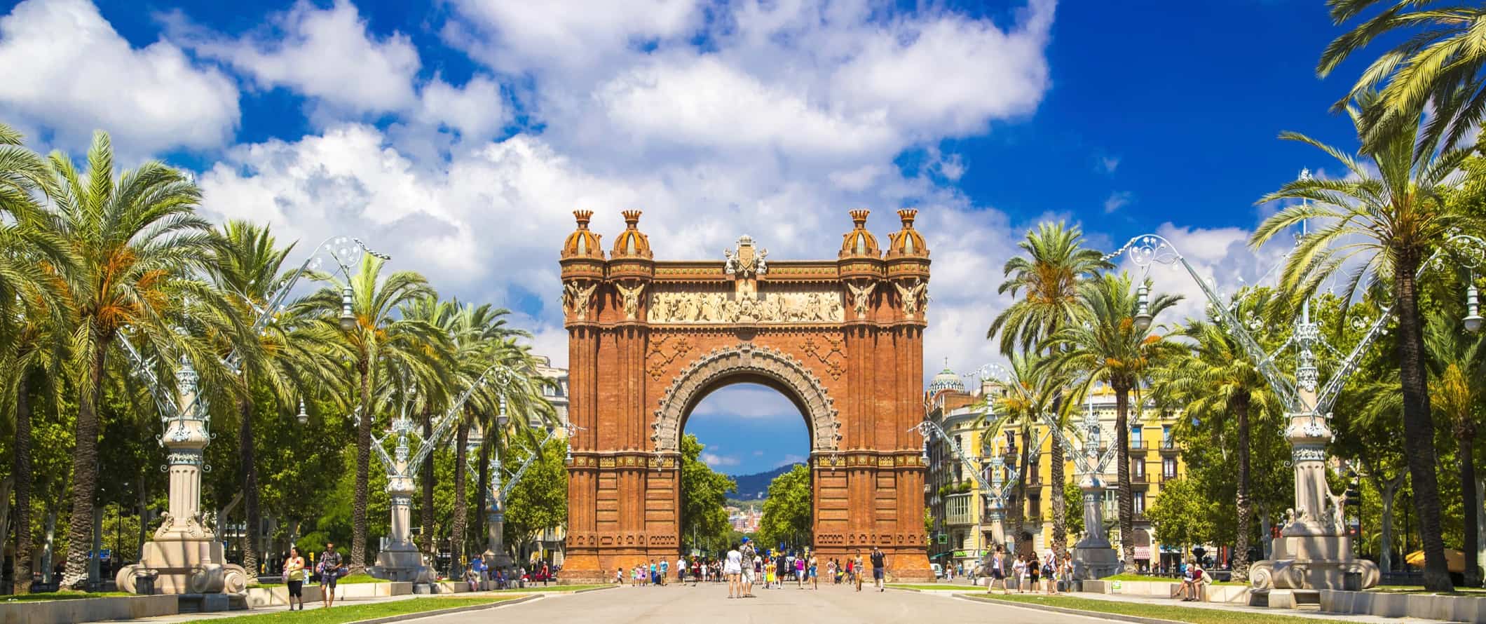 A wide open street in Barcelona, Spain with a huge arch