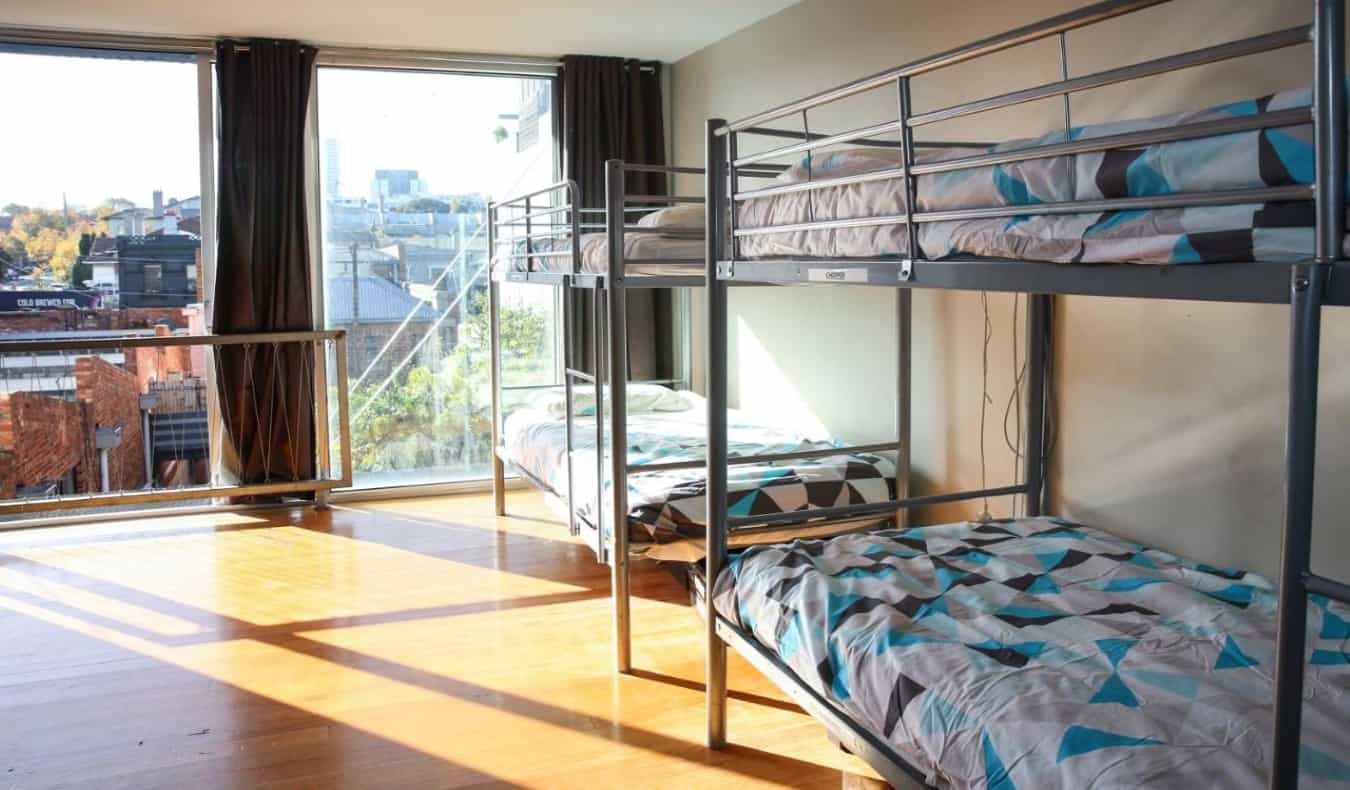 Colorful bunk beds in a light-filled dorm room at Barkly Backpackers hostel in Melbourne, Australia.