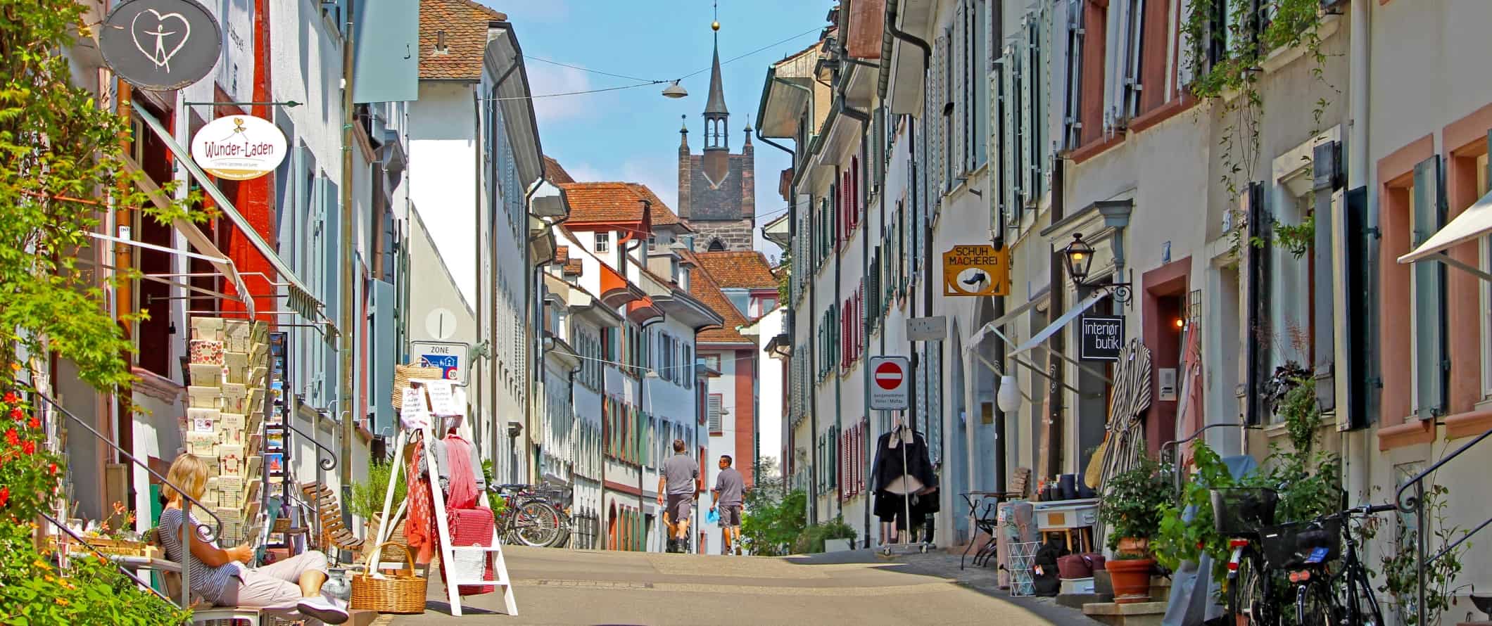A street lined with white buildings with brightly colored shutters in the historic center of Basel, Switzerland