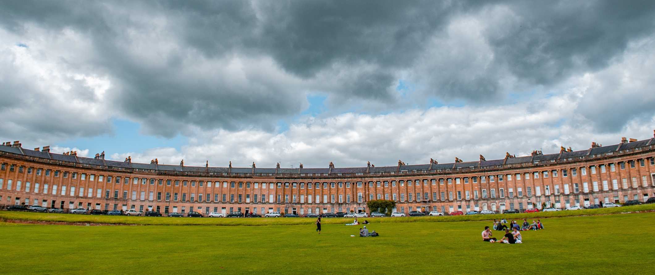 The expansive Royal Crescent, a crescent-shaped row of Georgian townhouses with a park in front in Bath, England