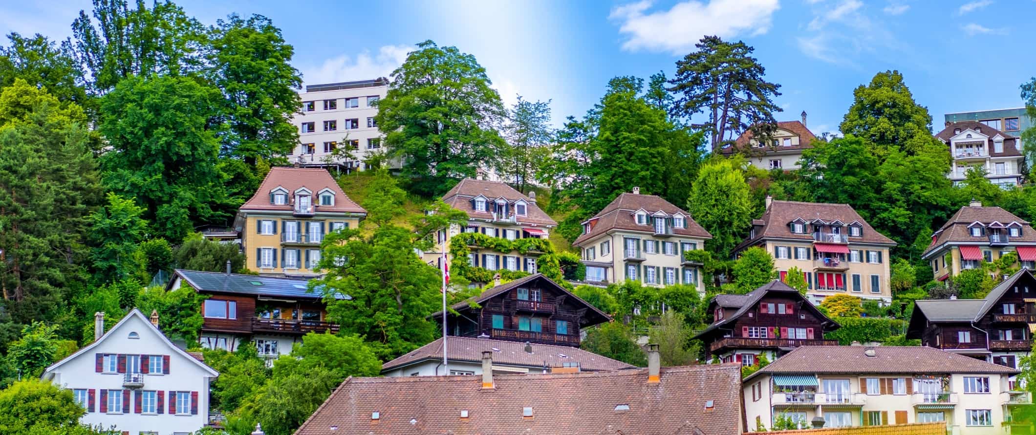 Colorful houses surrounded by trees, set into a hill in Bern, Switzerland