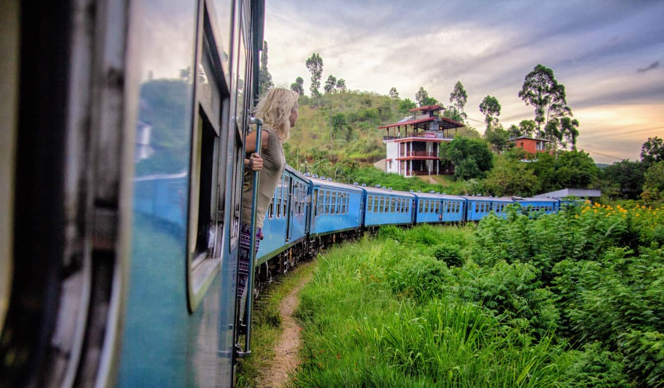 A woman on a train traveling around lush Sri Lanka
