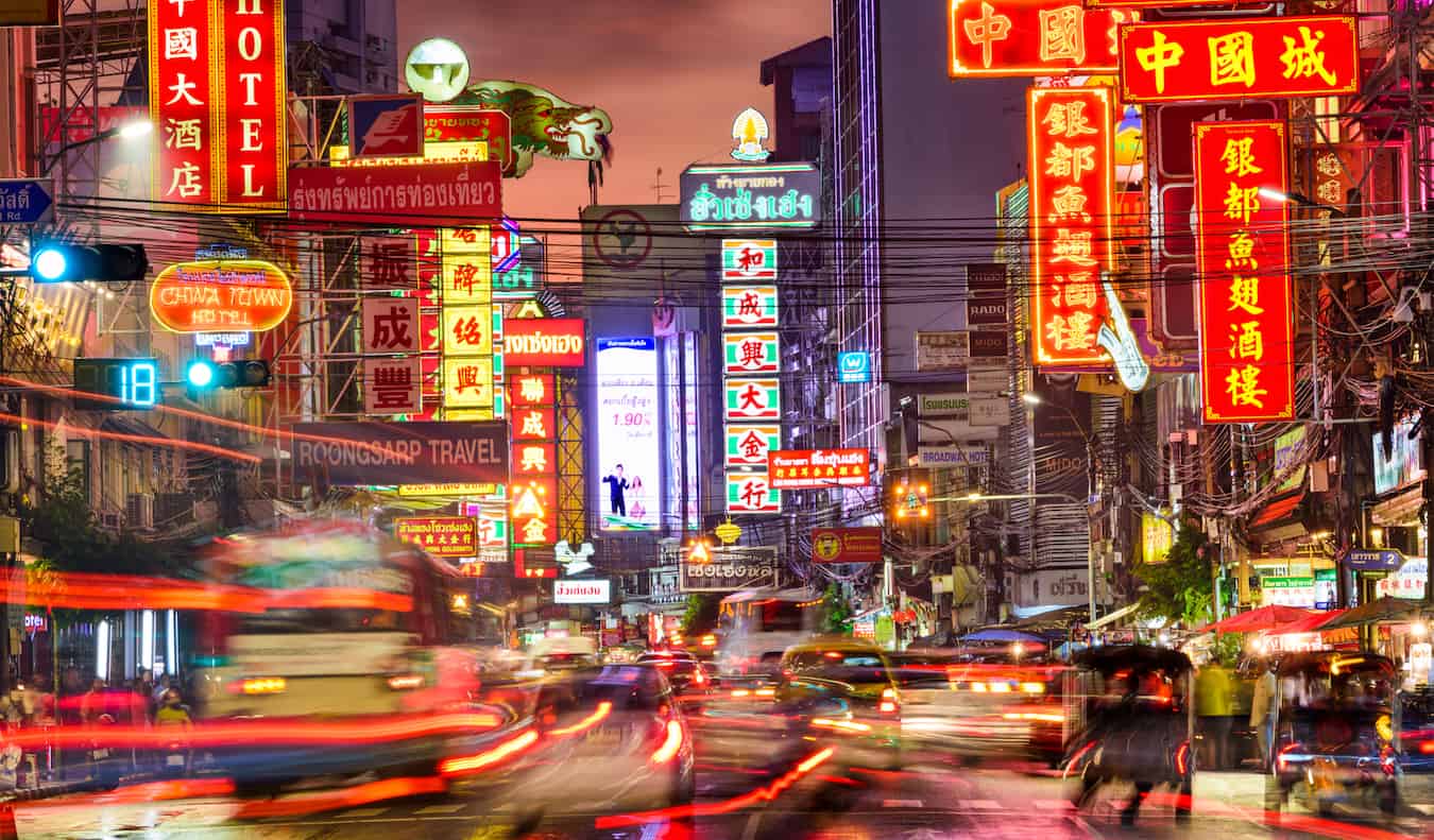 Blurred traffic and bright lights in Chinatown at night in Bangkok, Thailand