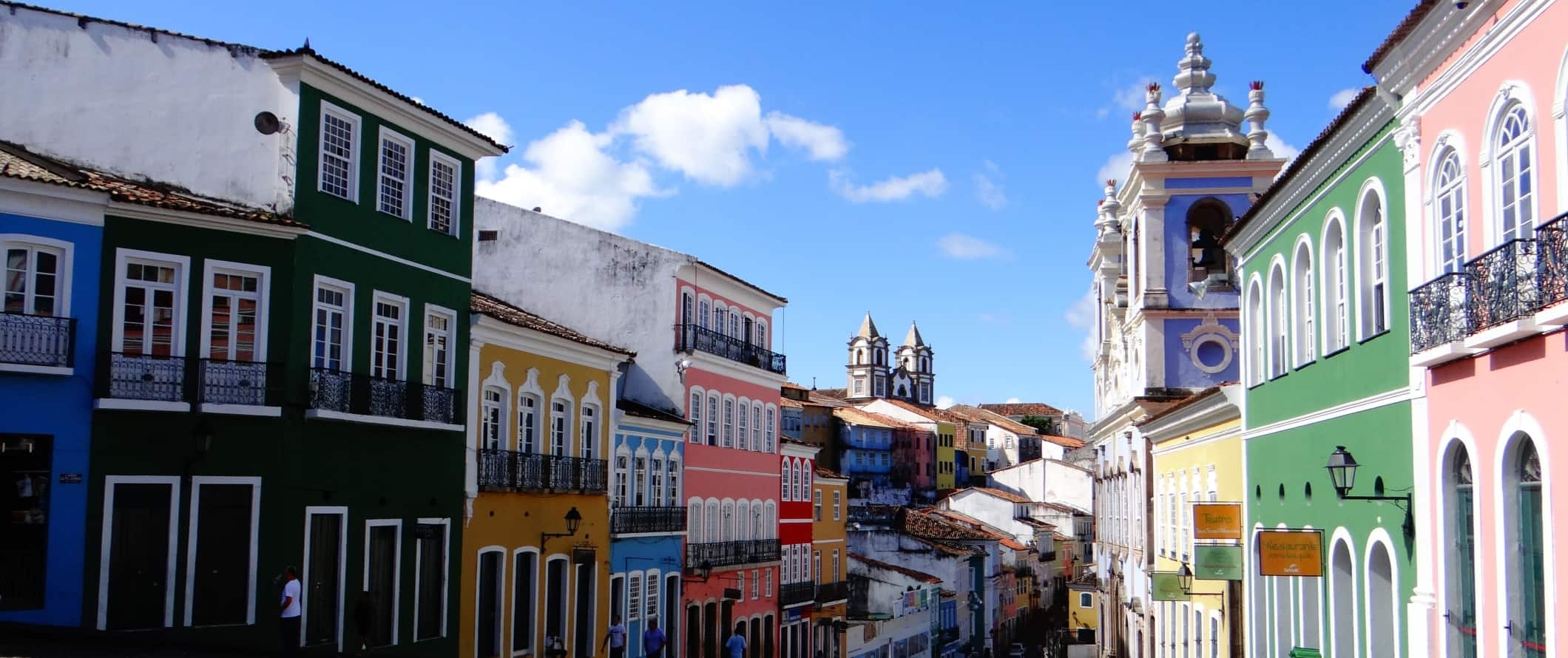 A street lined with brightly colored historic buildings in the city of Salvador, Brazil