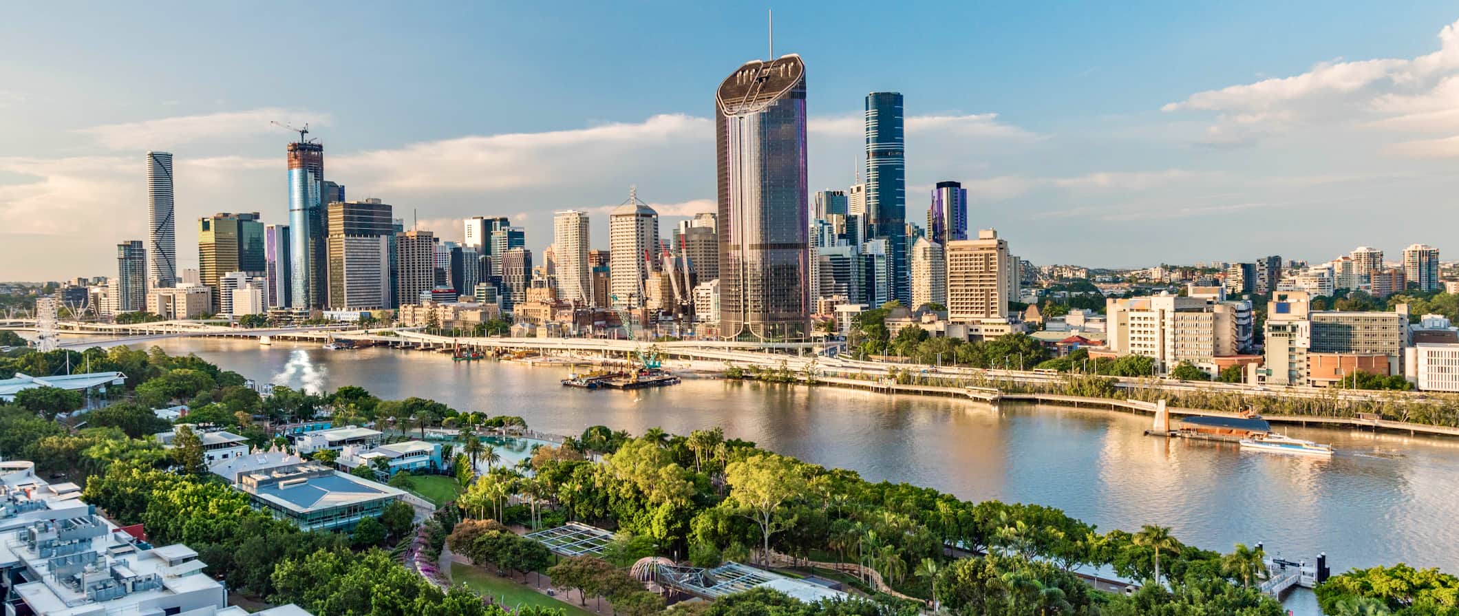 The towering skyline of Brisbane, Australia with lots of greenery across the river