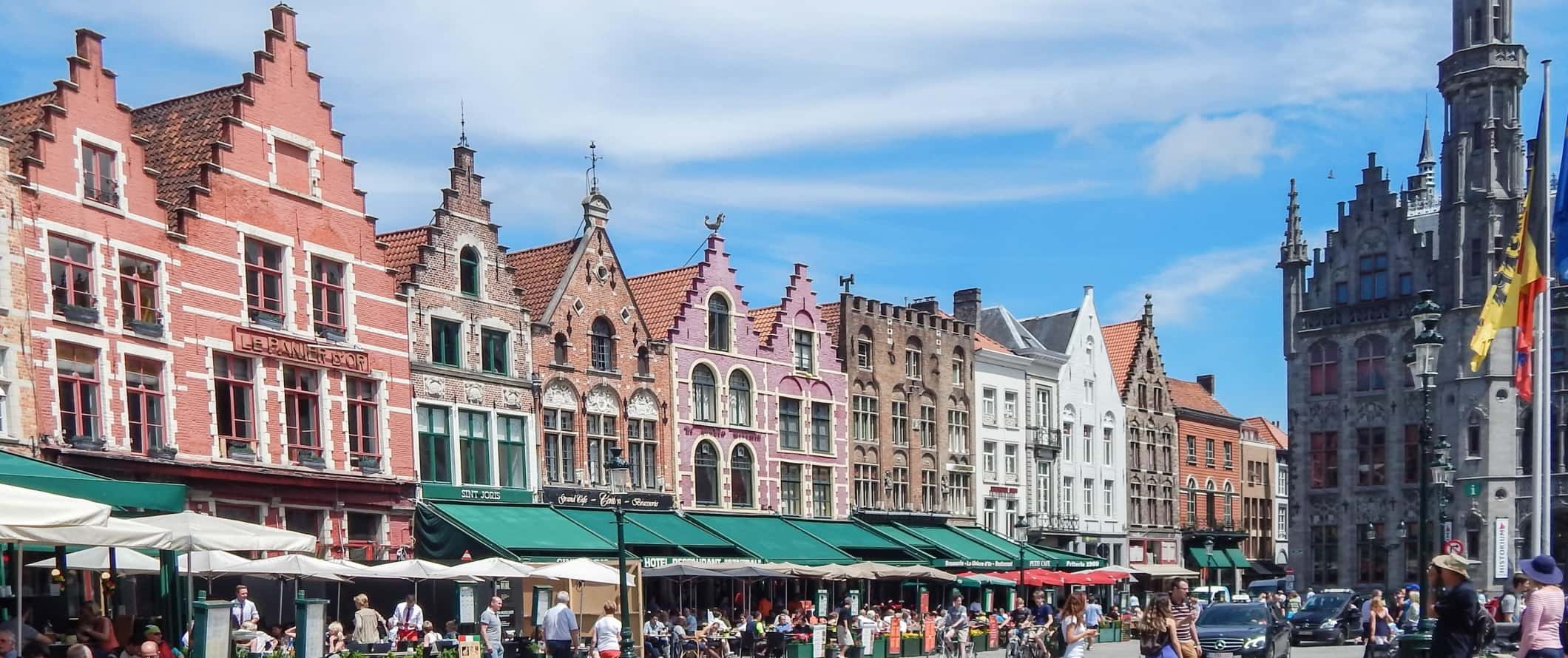 Grote Markt, the main historic square with colorful brick buildings in Bruges, Belgium.