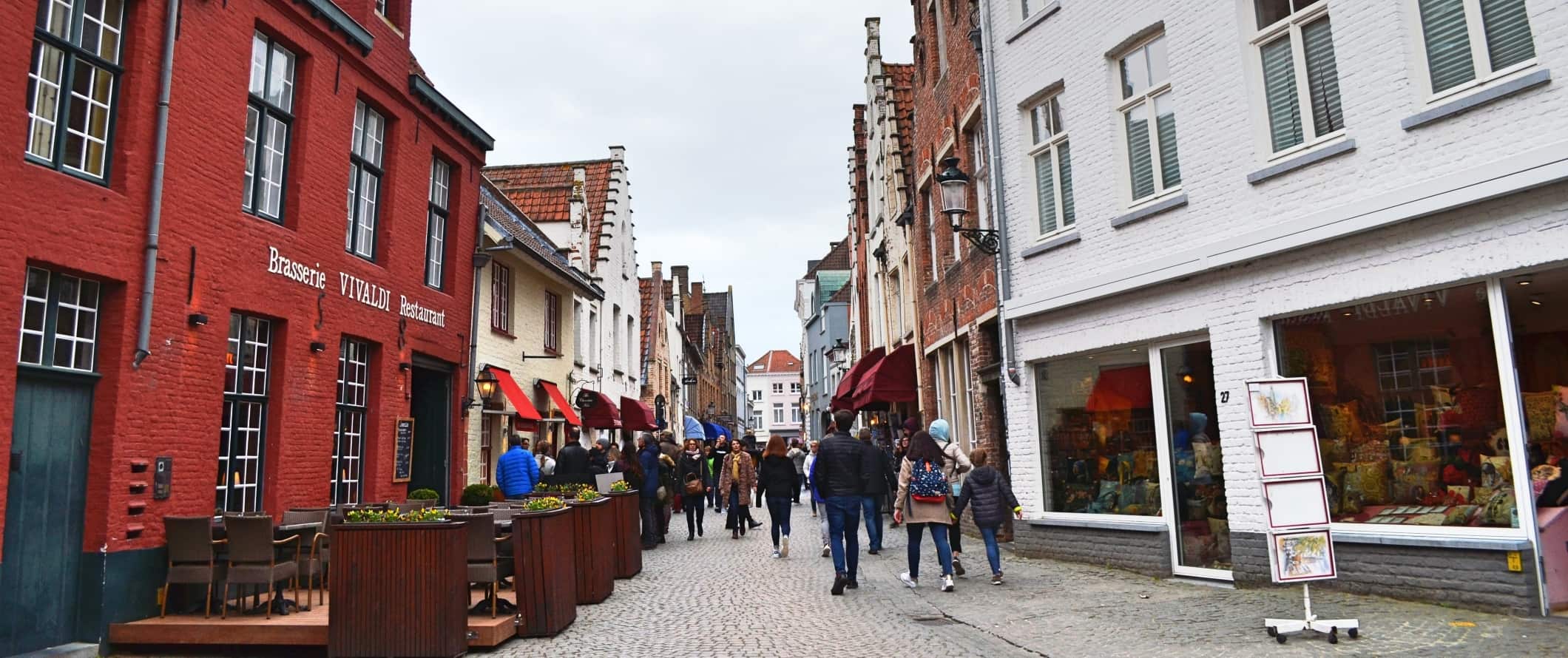 Cobblestone-street with people walking down it in Bruges, Belgium.