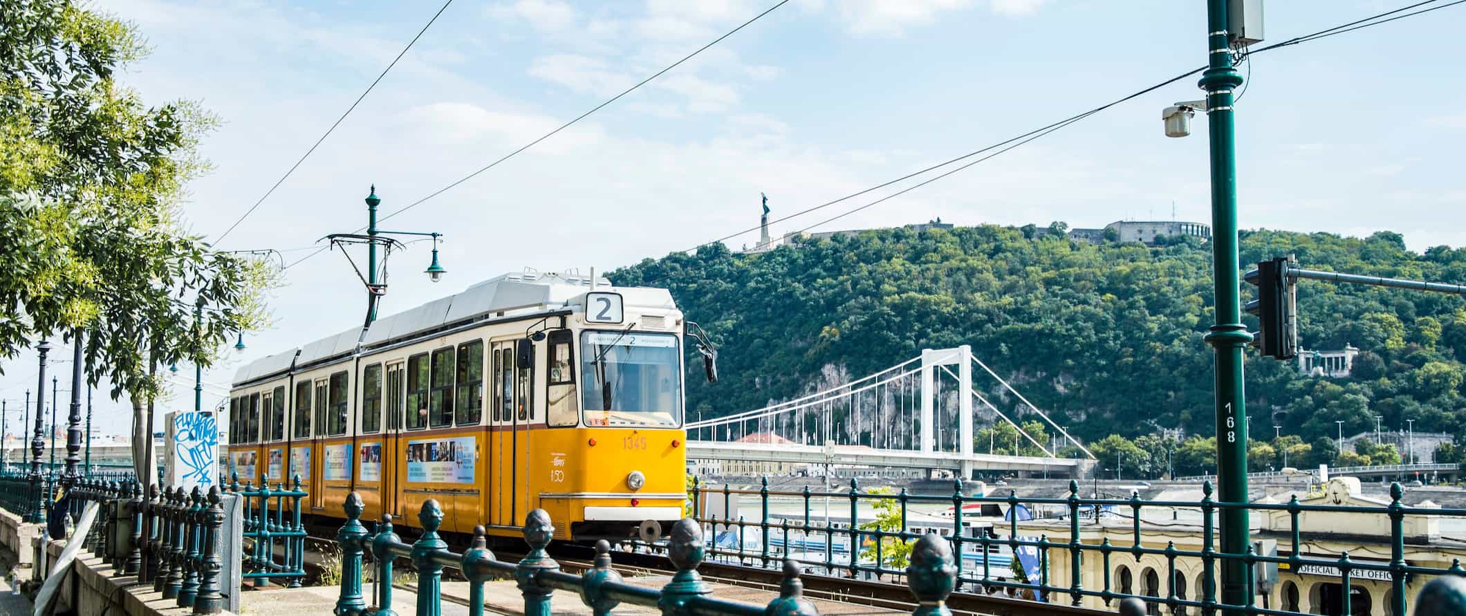 A yellow tram rolling along on a sunny day in Budapest, Hungary