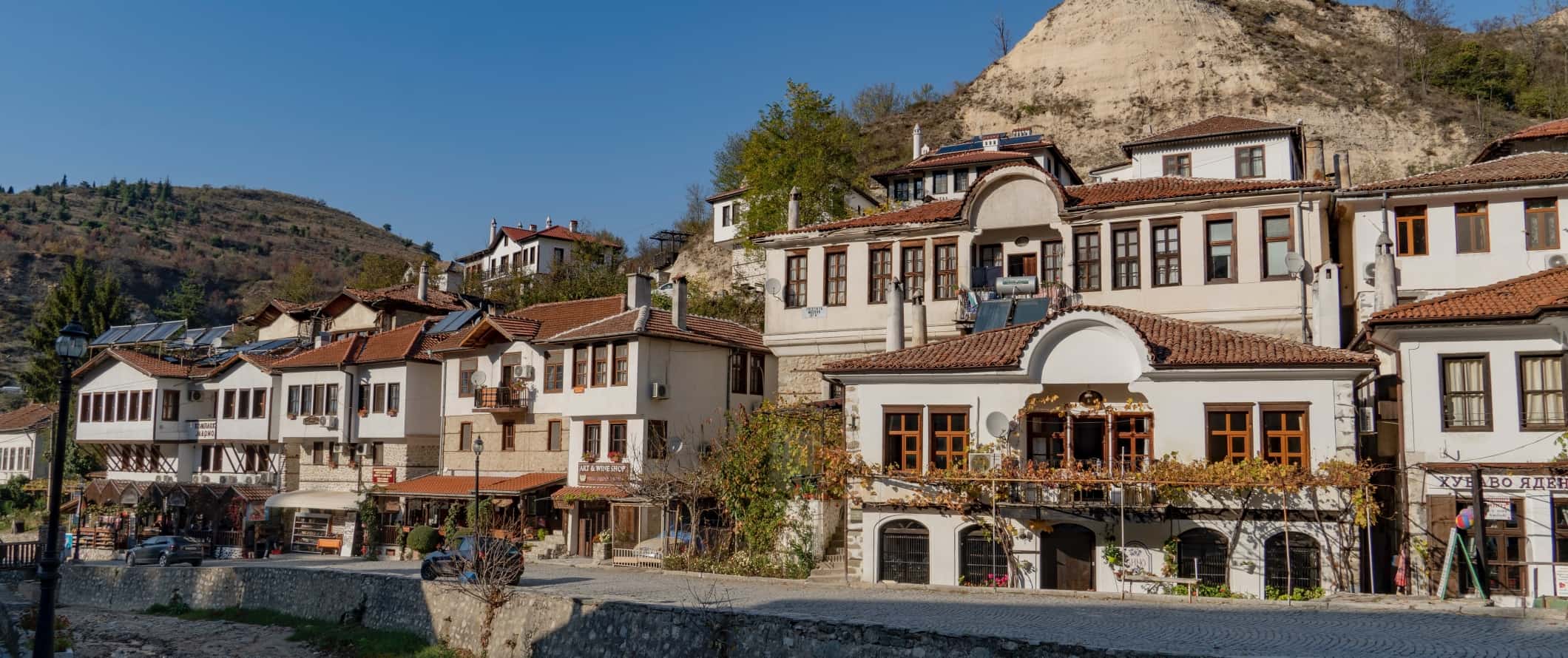 Traditional Bulgarian houses with terracotta roofs along a cobblestone street in a small village