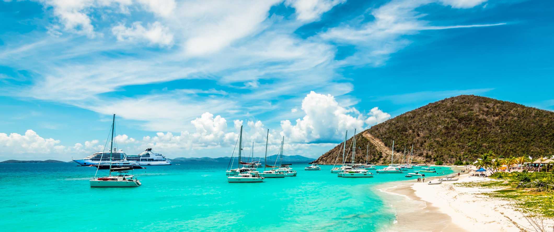 Sailboats parked in the azure waters of the party island of Jost Van Dyke in the British Virgin Islands
