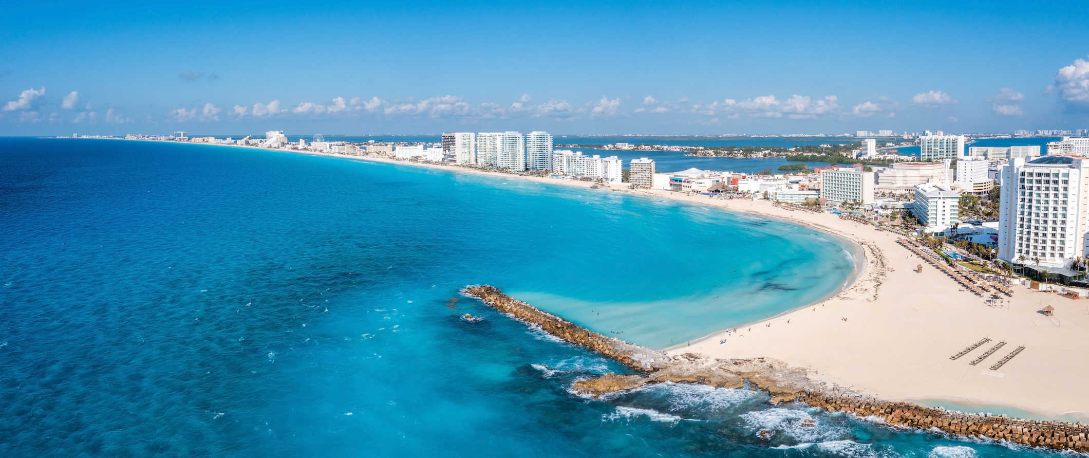The stunning coast of sunny Cancun, Mexico with resorts along the water and boats in the ocean