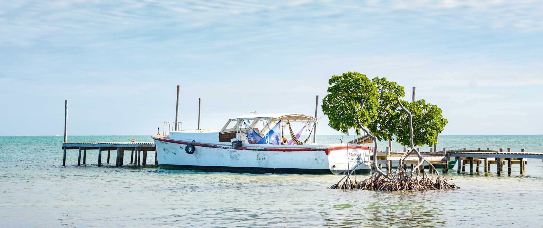 A boat at a dock in the waters of Caye Caulker, Belize