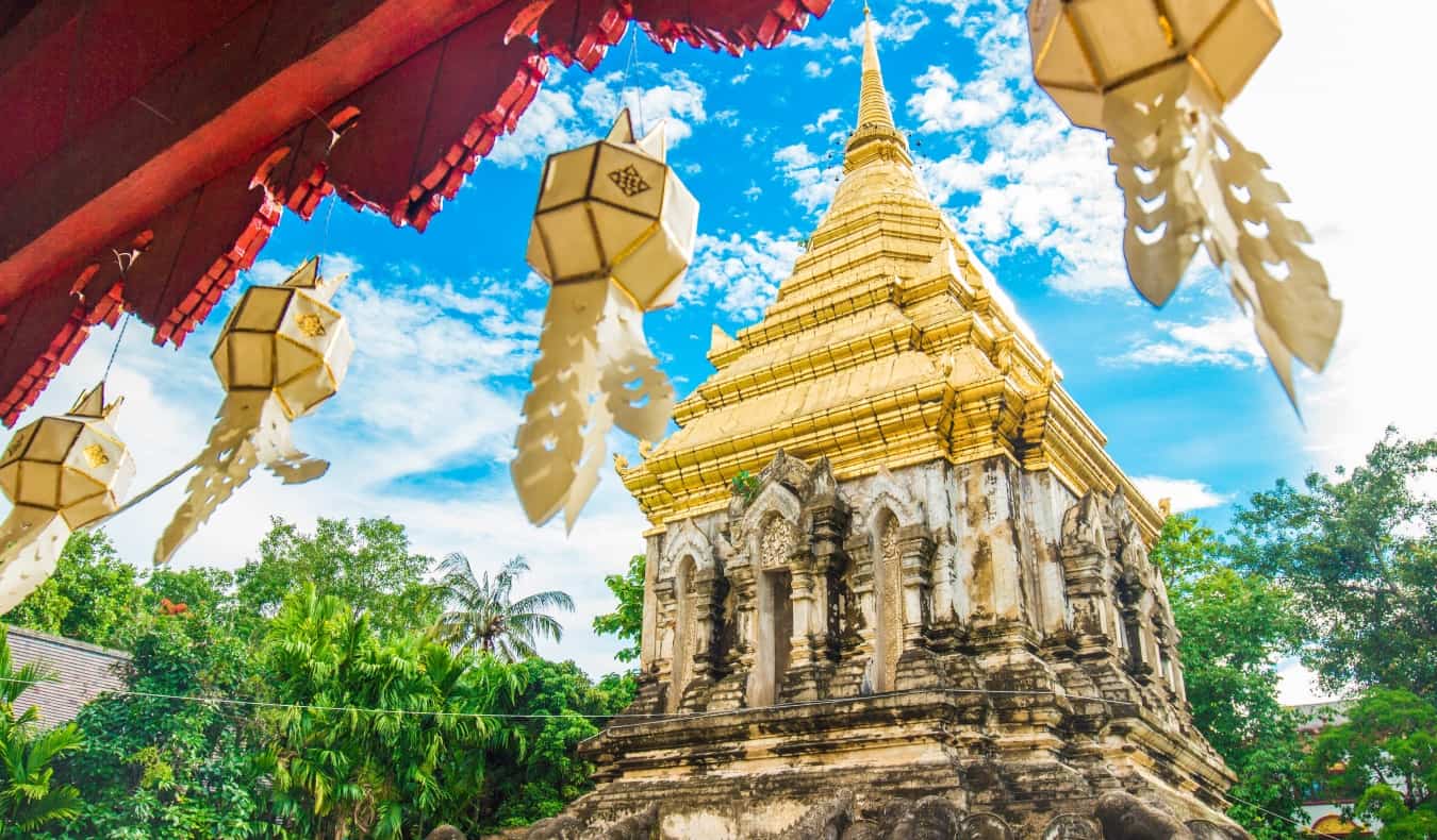 Buddhist temple with flags flying against a sunny sky in Chiang Mai, Thailand