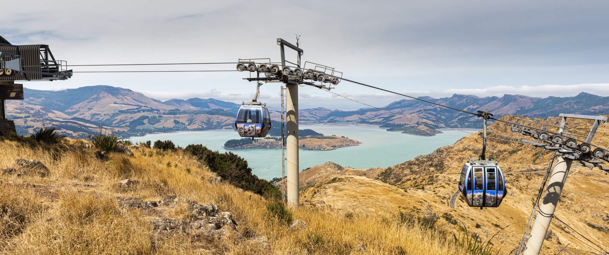 Gondolas with panoramic views of mountains and a large inlet in the background, in Christchurch, New Zealand.