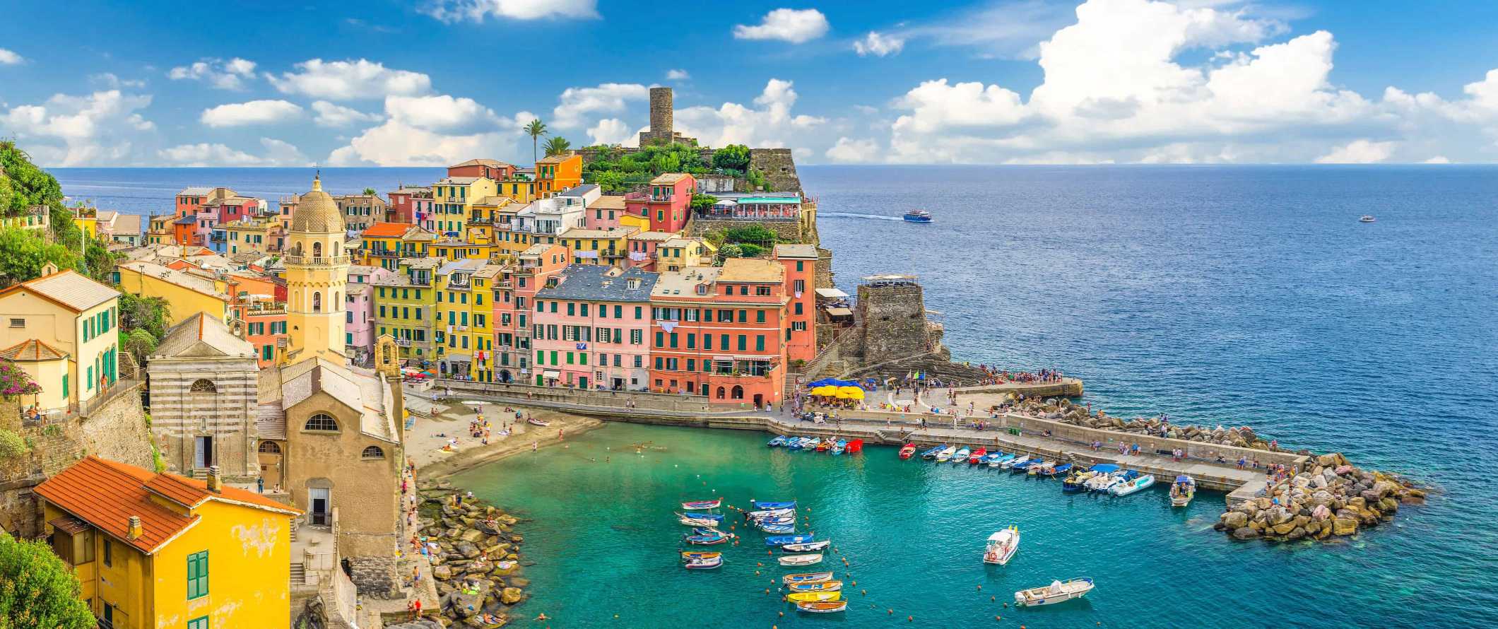 Colorful buildings and harbor filled with boats in the town of Vernazza in the Cinque Terre, Italy.