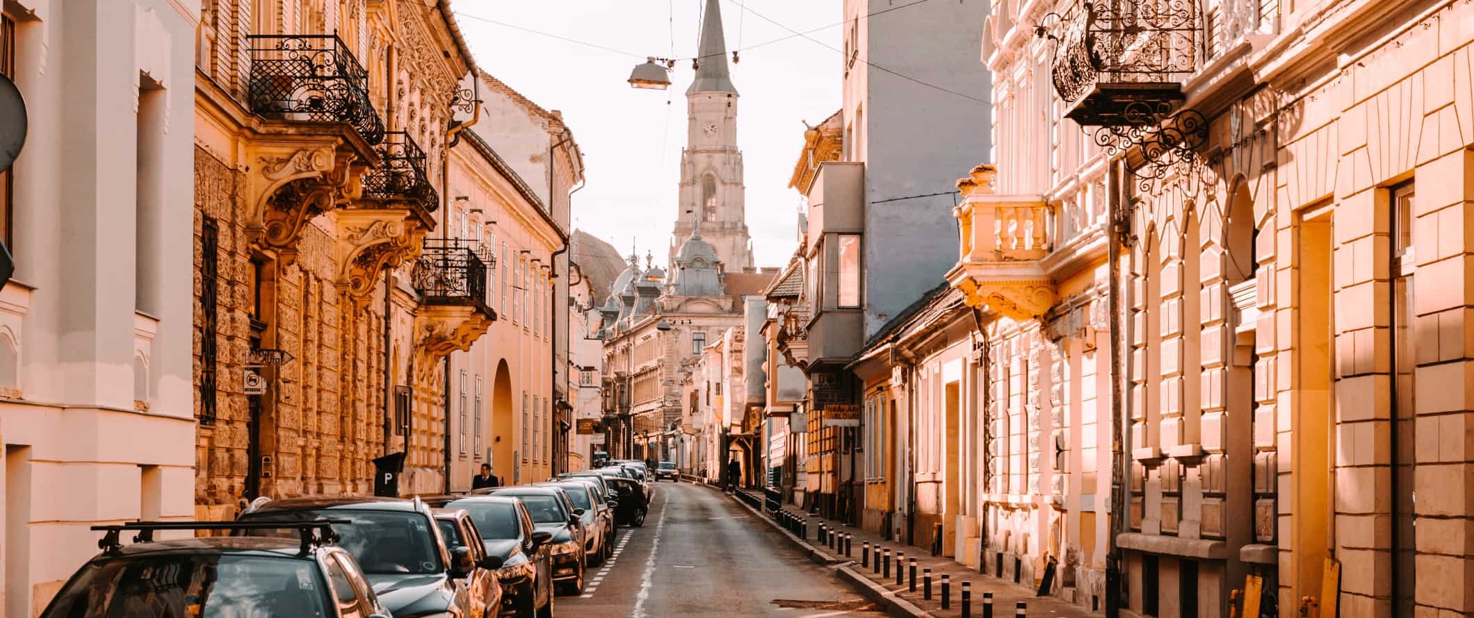 Historic streets in the late afternoon with a church in the background in city of Cluj-Napoca, Romania