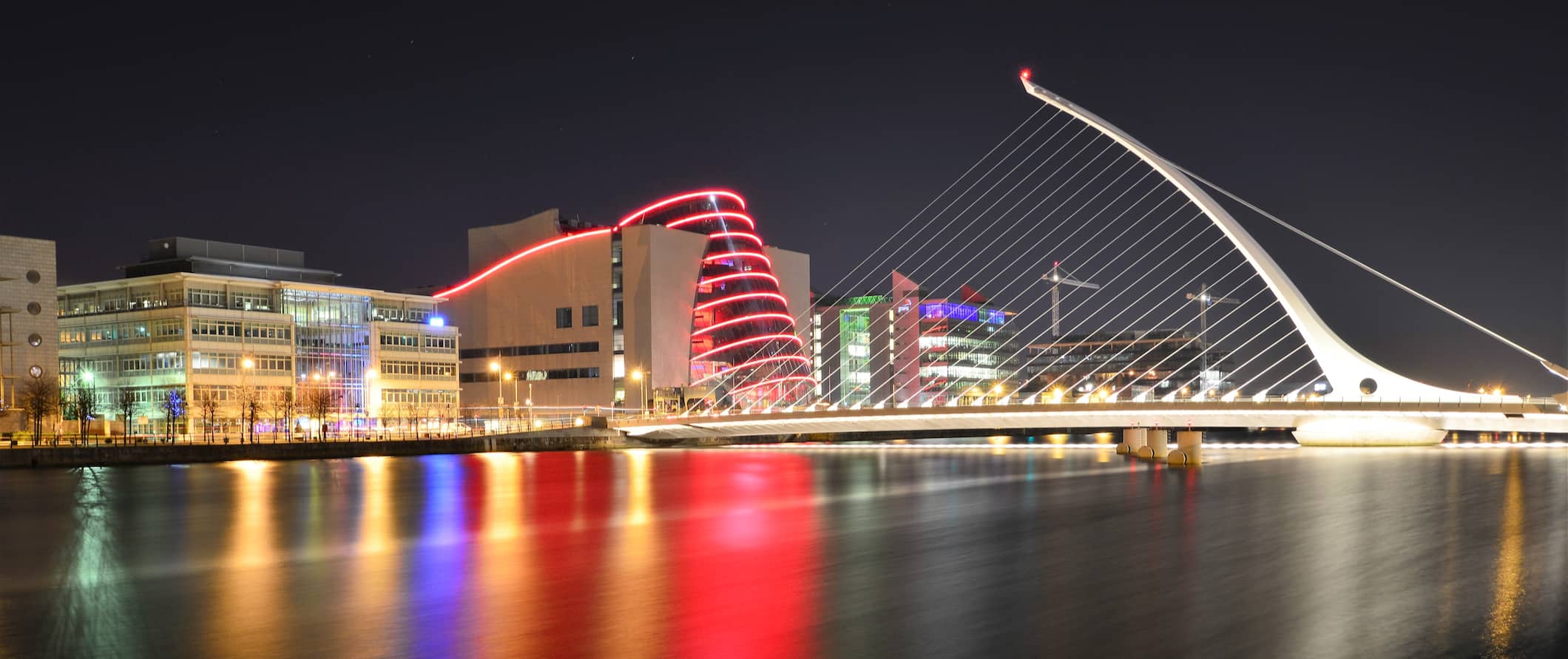 The city of Dublin, Ireland lit up by the water on a dark night