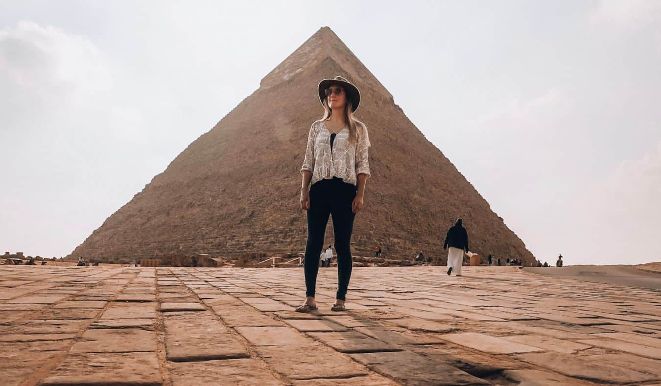 A lone traveler poses near the pyramids in Cairo, Egypt.