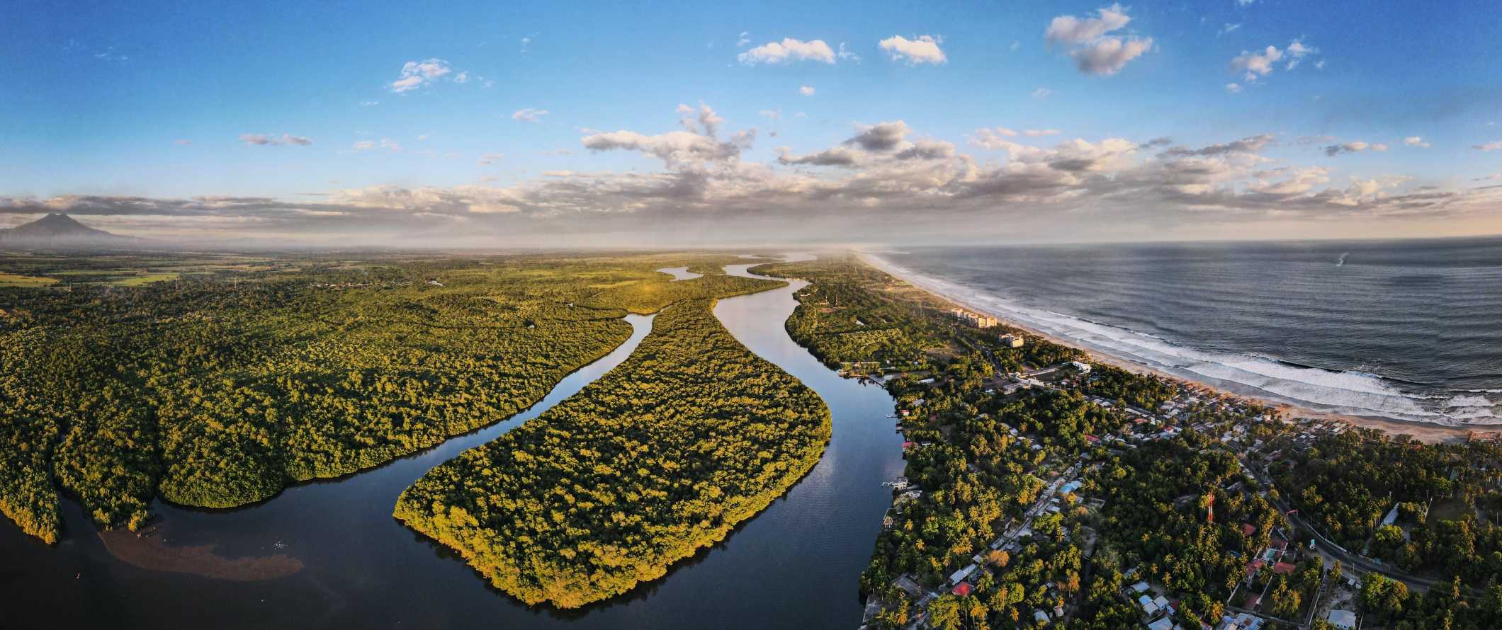 Aerial view of a lush green landscape and beaches in El Salvador