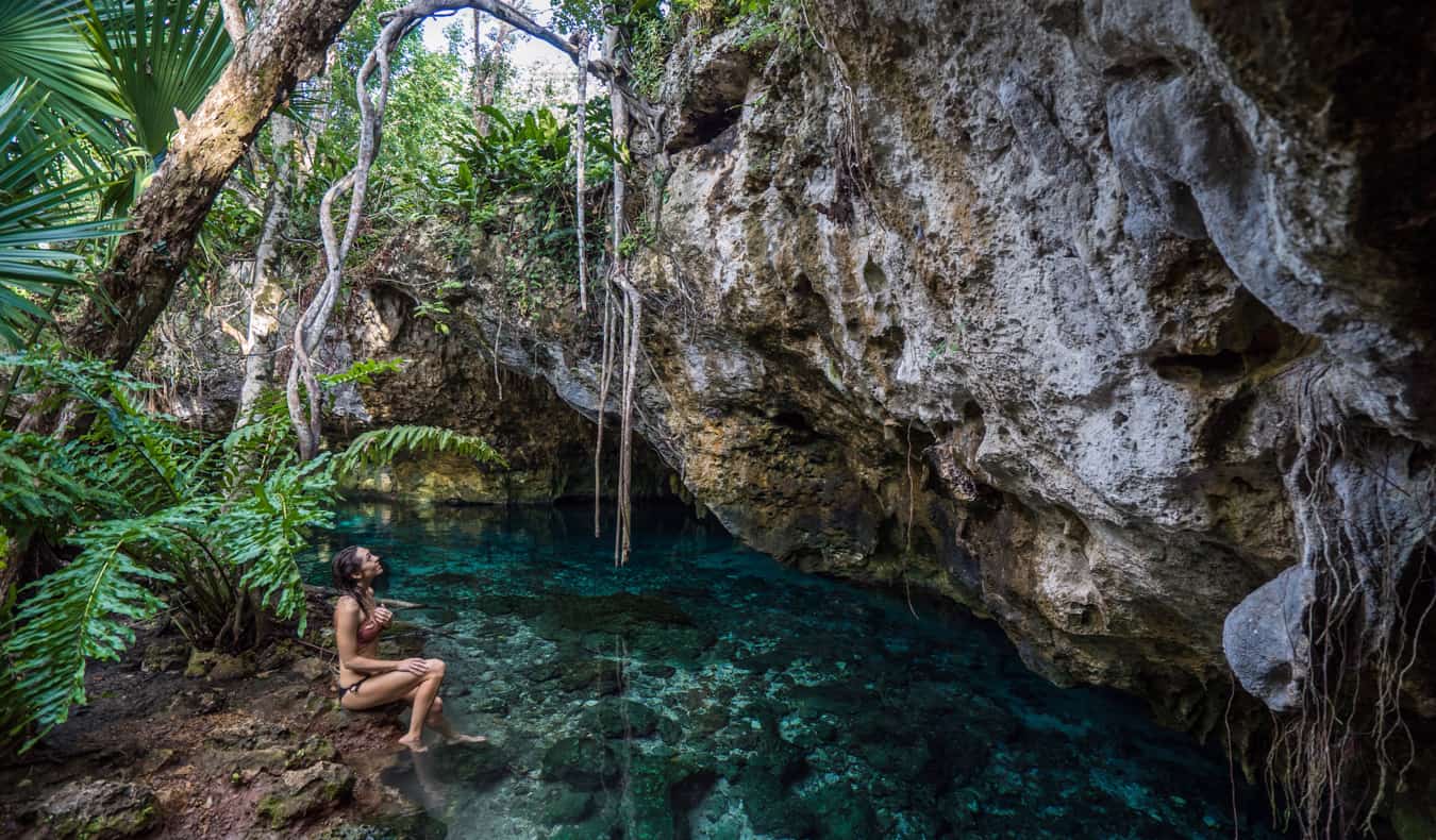 Solo female traveler Kristin Addiss in Mexico relaxing by a jungle cenote