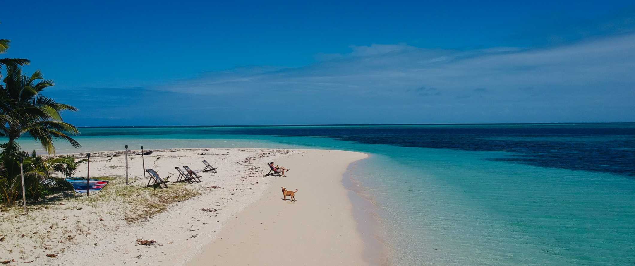 A person lounging in a beach chair on a remote beach in Fiji